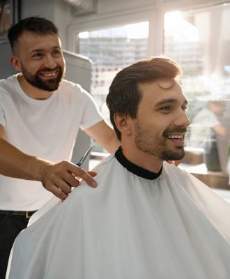 Happy male client of hair salon looking contented with haircut Happy male client of hair salon looking contented with haircut